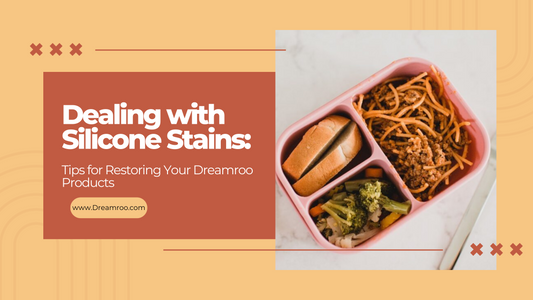 Dealing with silicone stains: tips for restoring your Dreamroo products. Pink bento box with garlic bread, broccilli, and pasta with meat sauce. travel utensil set next to bento